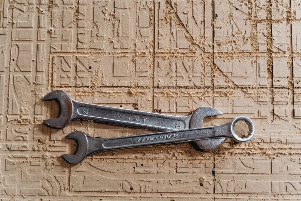 pexels photo 7480238 7480238 Two metal spanners placed on a textured wooden surface, showcasing industrial tools.